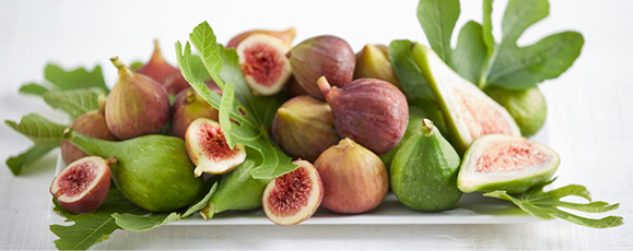 c'est la photo de plusieur figues verte et violette , sur un  platau entremelacées de feuille de fiqguier